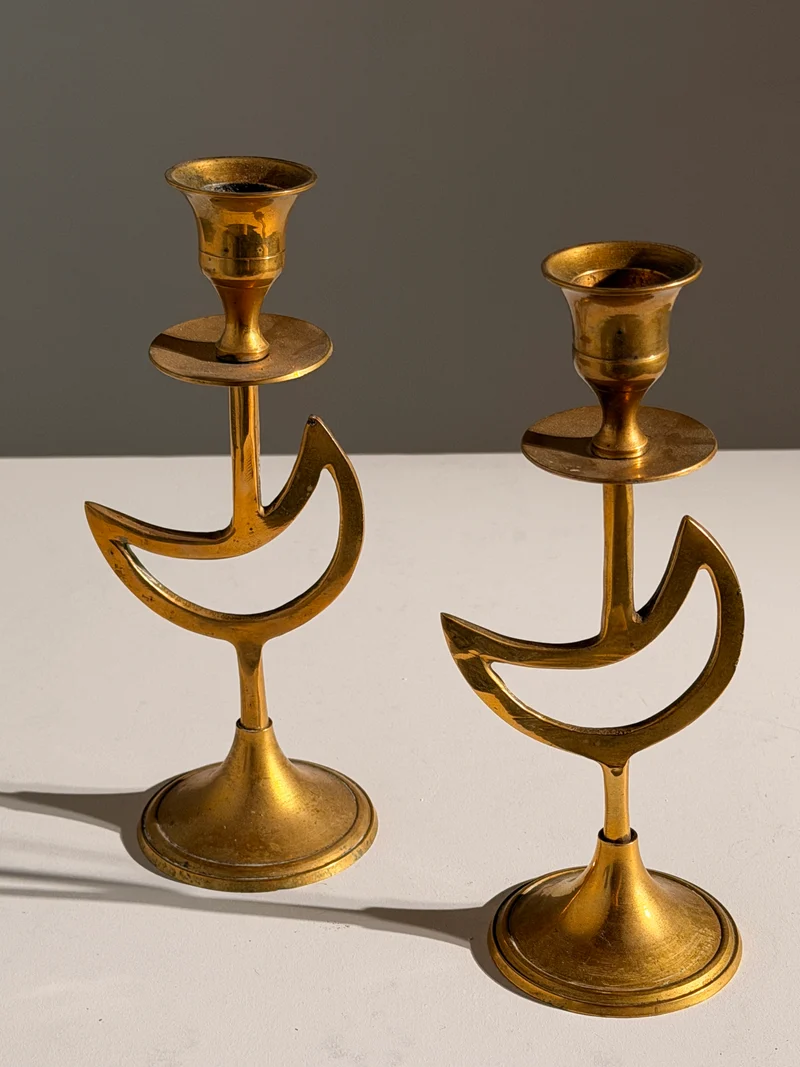 Pair of brass candlesticks with a crescent-moon motif, France, circa 1970